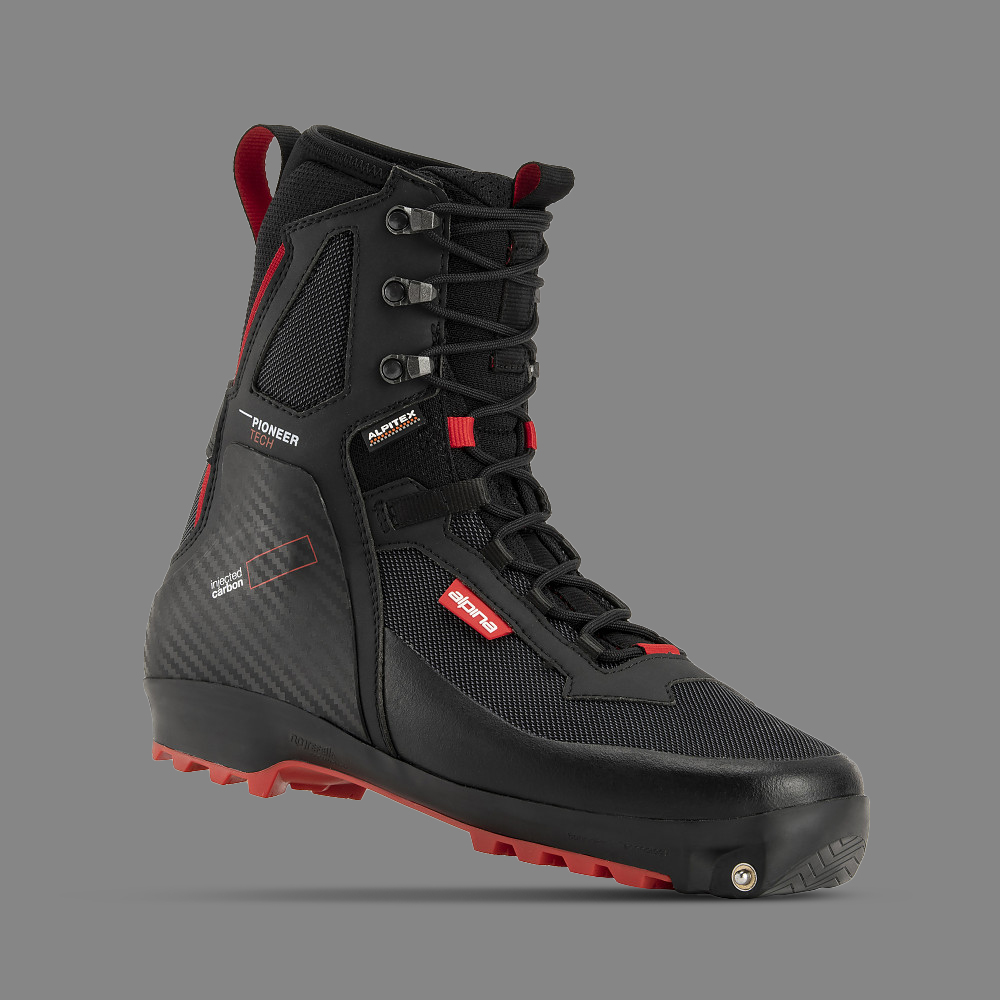 Alpina Backcountry ski boot, designed for off-track cross-country skiing in extreme conditions. The black and red boot features a high ankle, injected carbon heel support, red tread sole, and flexible rear section with added comfort zones. Durable, water-resistant, and insulated for rugged terrain and harsh weather, with red accents highlighting key functional elements.