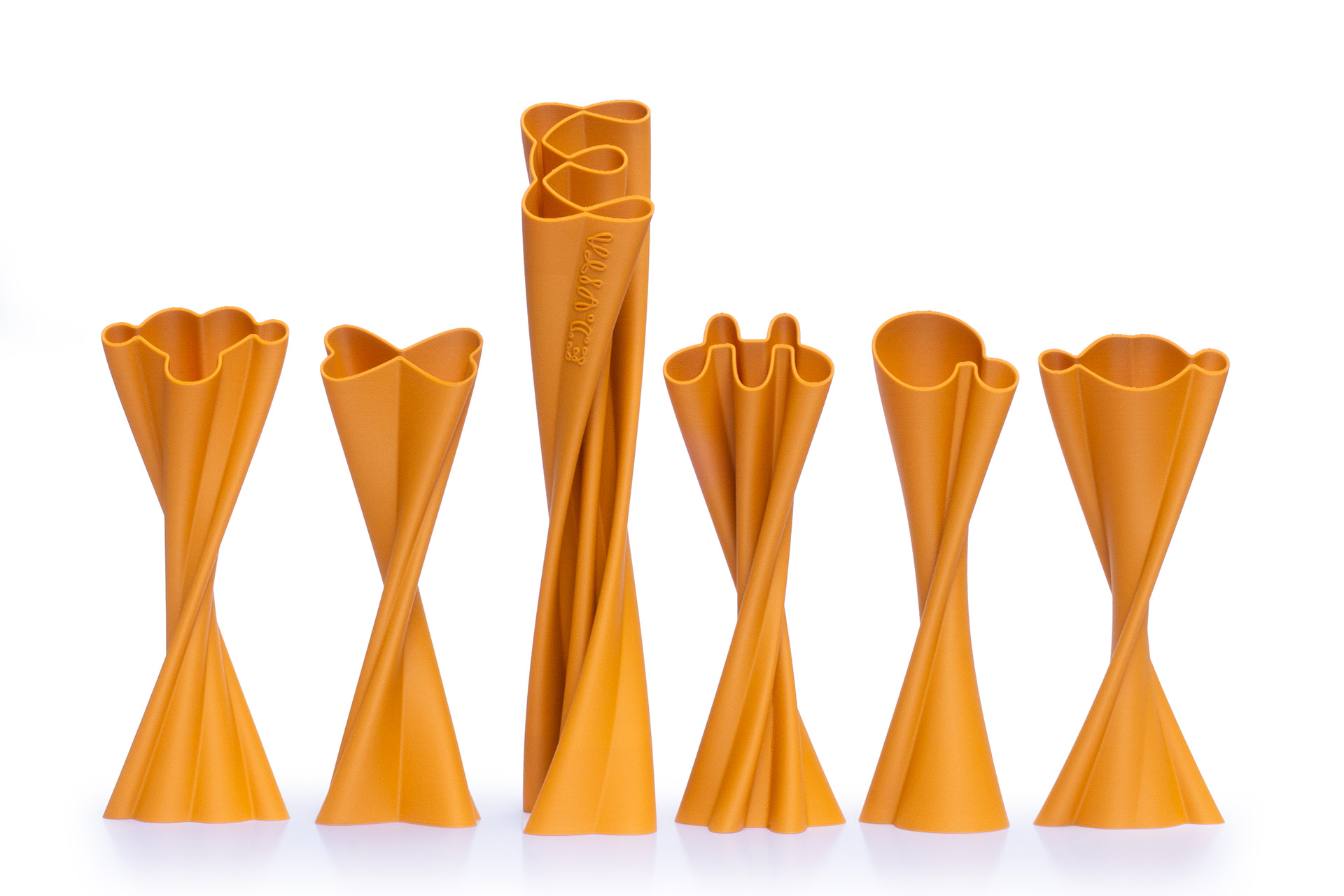 3D printed ED.VITA trophies displayed together, featuring one large main award and five smaller thematic trophies, showcasing extruded logo forms, elegant line design, and sustainable PLA-wood material suitable for industrial composting for the Sustainability in Education Award.