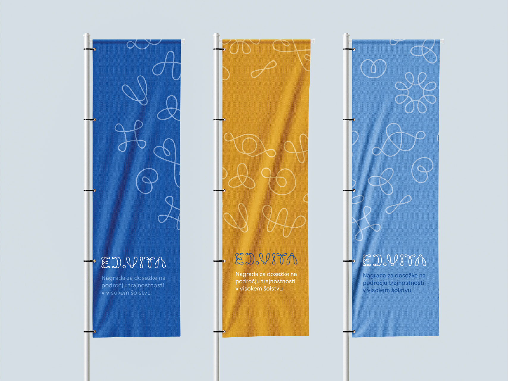 Three flags featuring the ED.VITA typographic line logo in blue and orange, representing sustainable design and award identity.