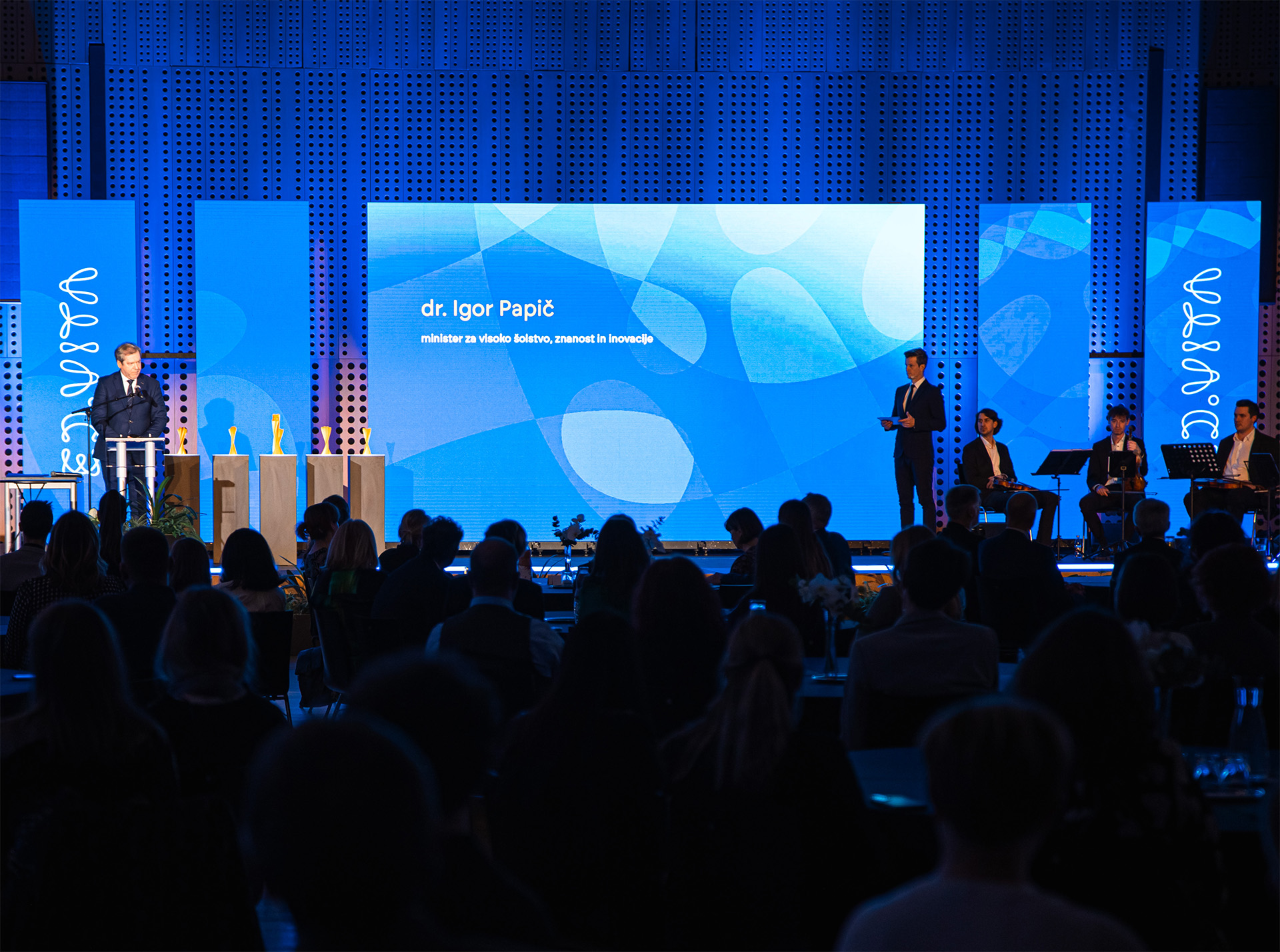 Photo of the ED.VITA national sustainability in education award event ceremony with background graphic design on the displays.