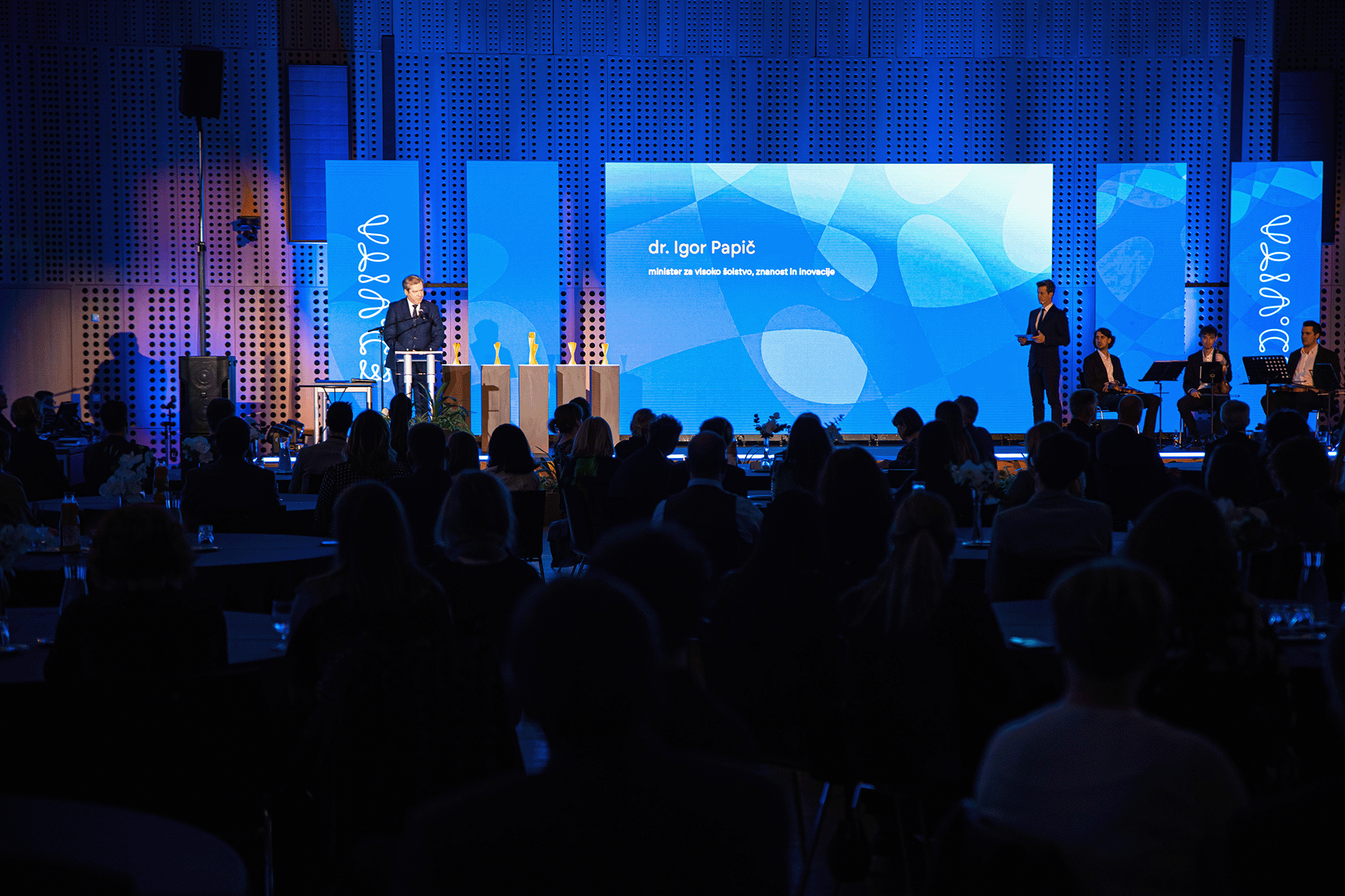 Photo of the ED.VITA national sustainability in education award event ceremony with background graphic design on the displays.