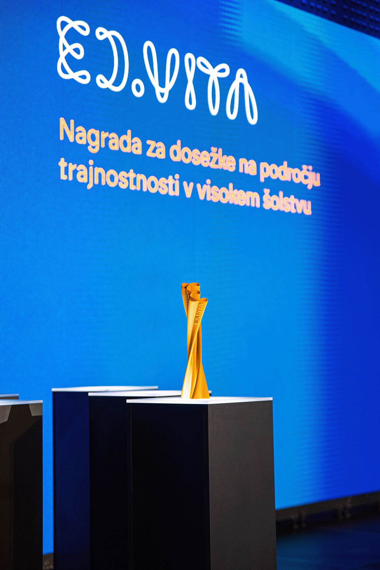A photo of the grand award 3D printed ED.VITA trophy on stage at the Sustainability in Education Award ceremony.